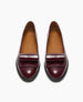 A pair of shiny, burgundy leather loafers with tan insoles and black soles, viewed from above. 6