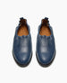 A pair of blue leather slip-on shoes with a gathered elastic top and a brown insole featuring a logo. 4