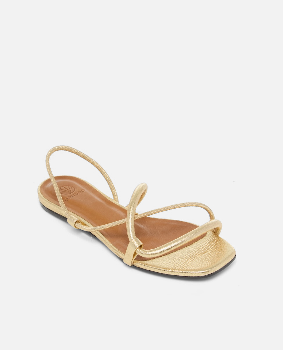 Angled view of a crinkled metallic gold flat sandal with slim cylindrical padded straps and an elasticated slingback, square toe, on a white background.