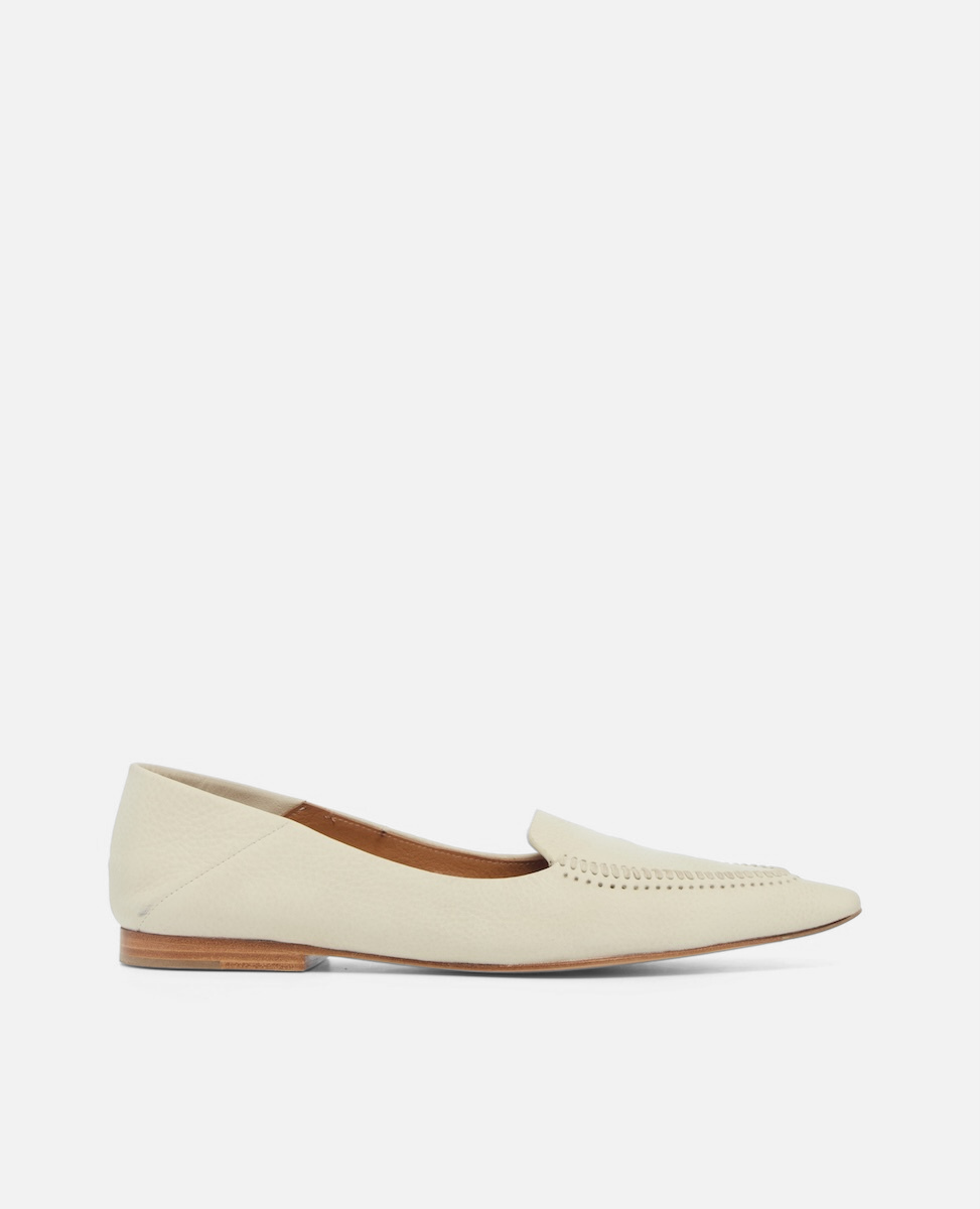 Side view of a pointed-toe white nubuck leather loafer with topstitch detailing and a flat leather sole on a white background