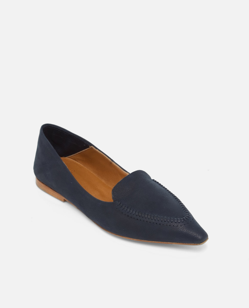 Angled view of a pointed-toe navy nubuck leather loafer with topstitch detailing and a flat leather sole on a white background