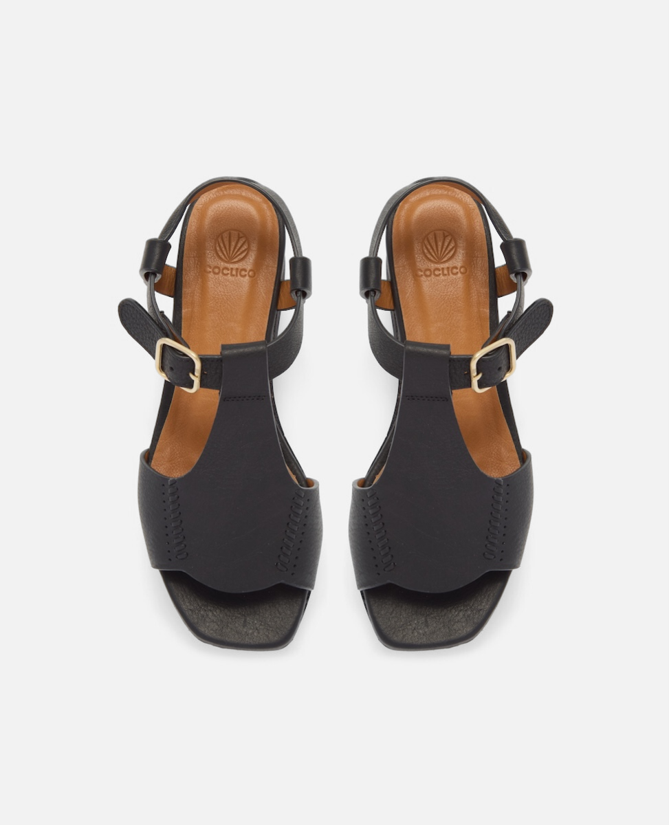 Top view of a black leather wedge sandal with wide stitched straps, adjustable ankle buckle, and a black-stained cork platform sole