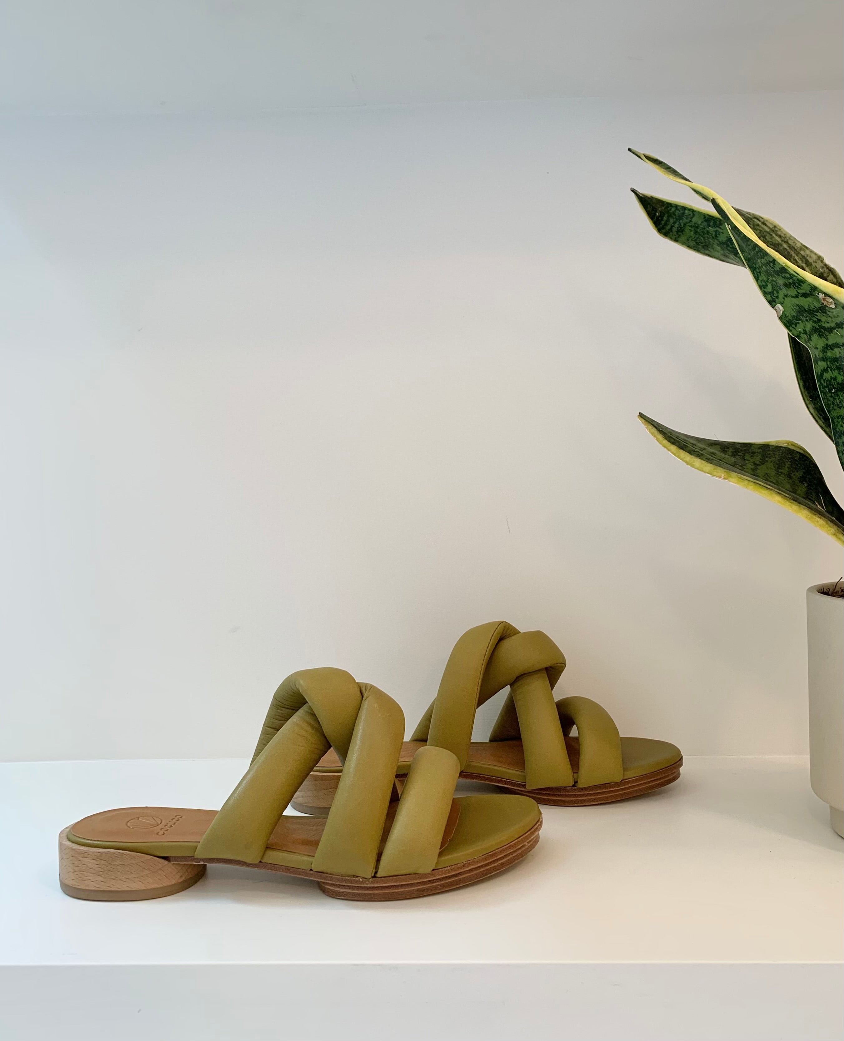 Side view of the Everly Sandal in Torbollino Olive leather, twisted padded straps and a draised two-part leather sole.