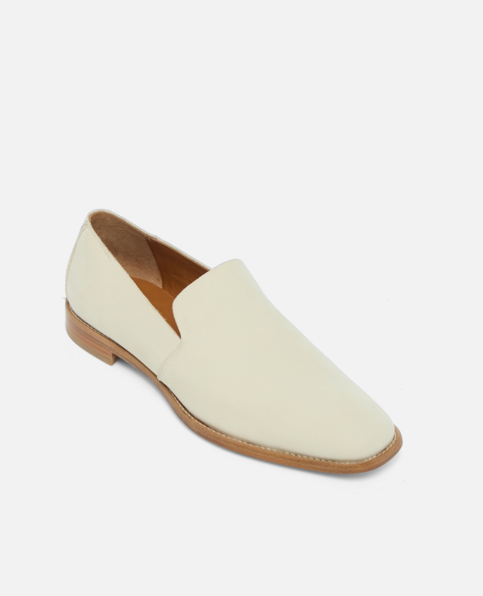 Angled view of a white nubuck leather slip-on loafer with a tapered square toe and low stacked heel on a white background