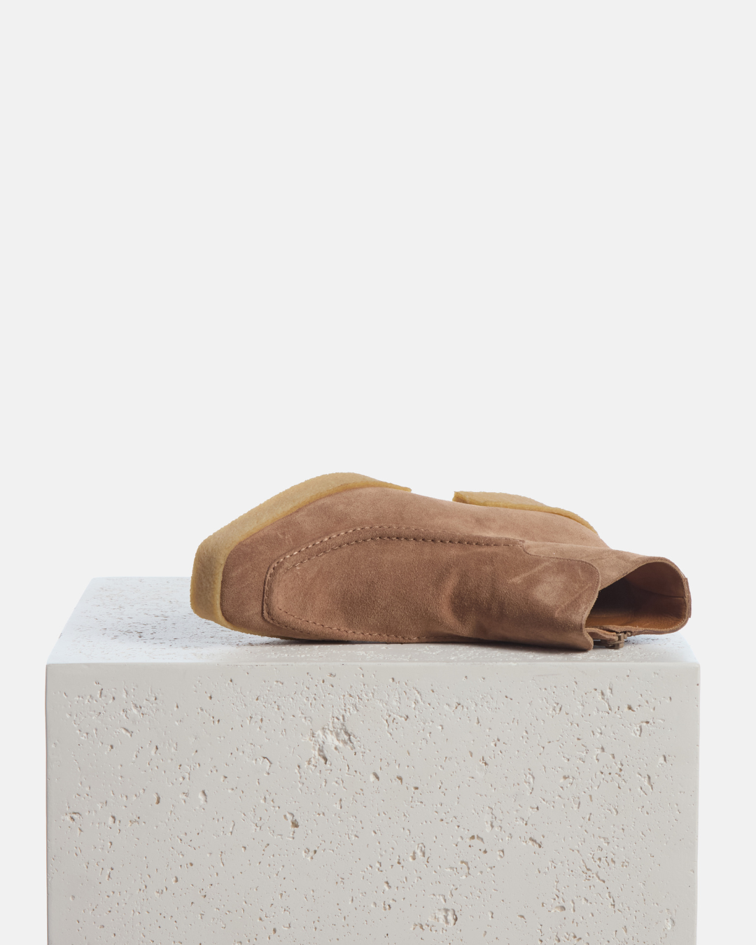 Coclico Boudica Boot in Dust split suede, ankle boots with natural crepe soles styled on a stone plinth