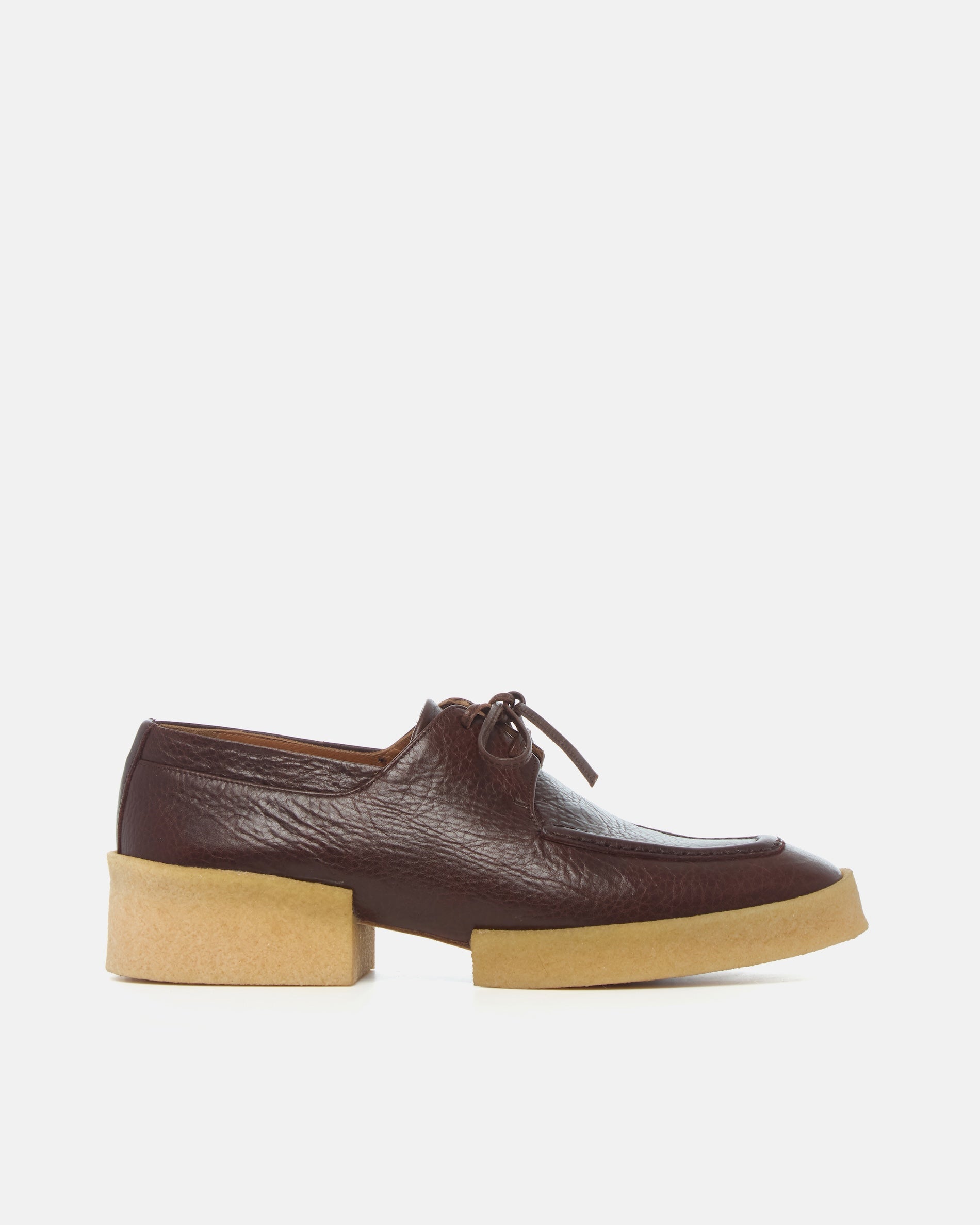 Brown leather shoe with a crepe split sole on a white background