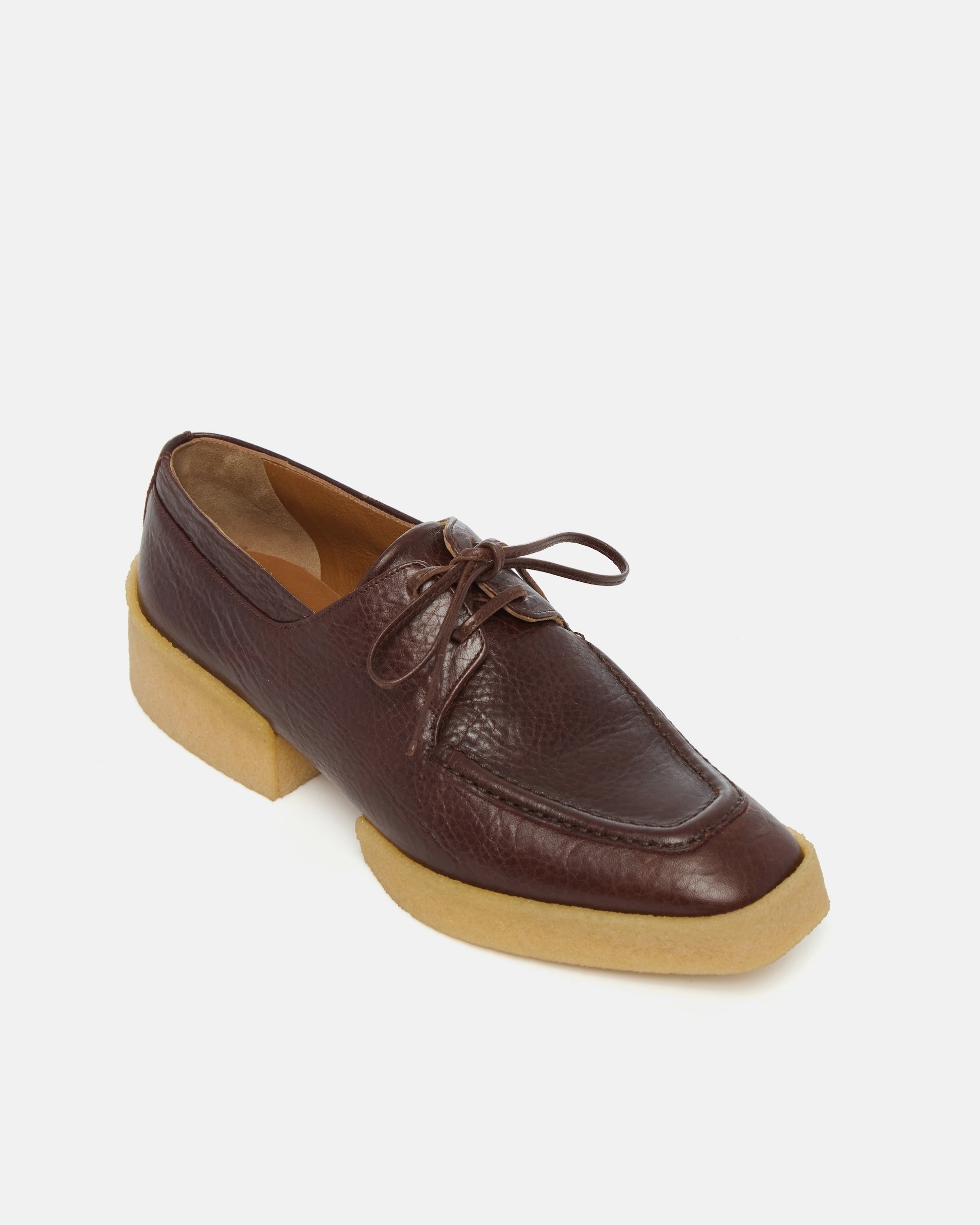 Brown leather shoe with a crepe split sole on a white background