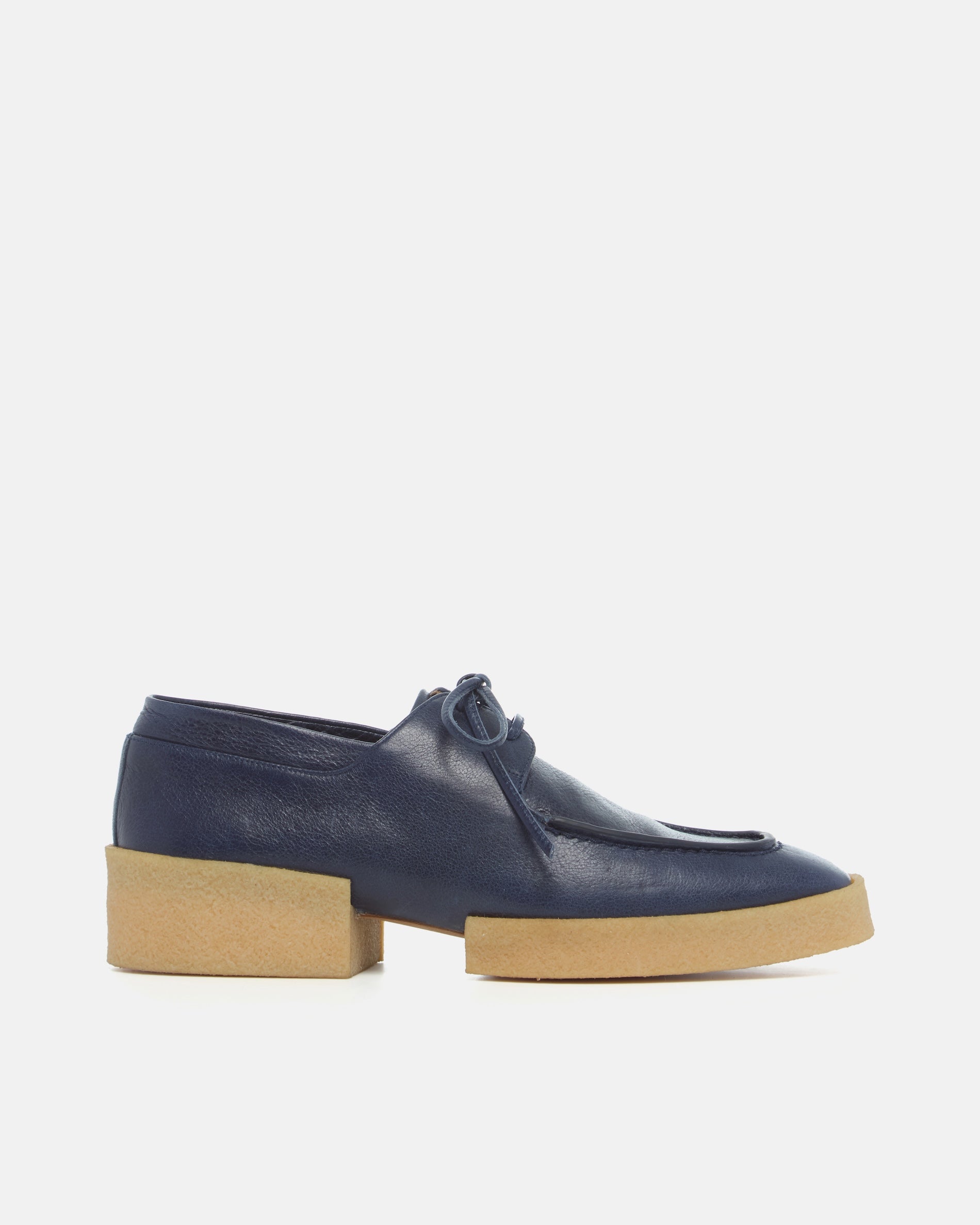 Navy blue loafers with a crepe split sole on a light gray background