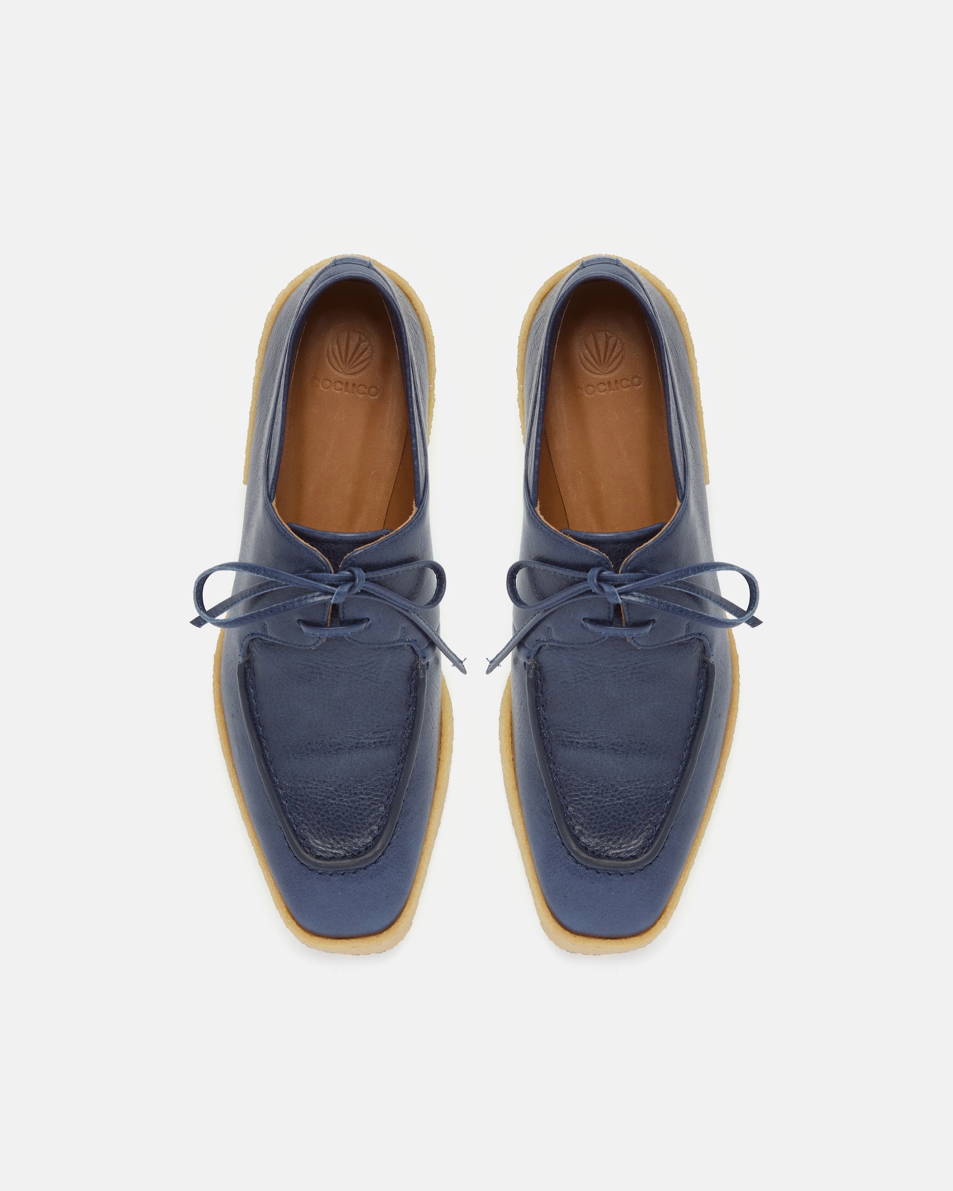Pair of navy blue loafers with a crepe split sole on a light gray background