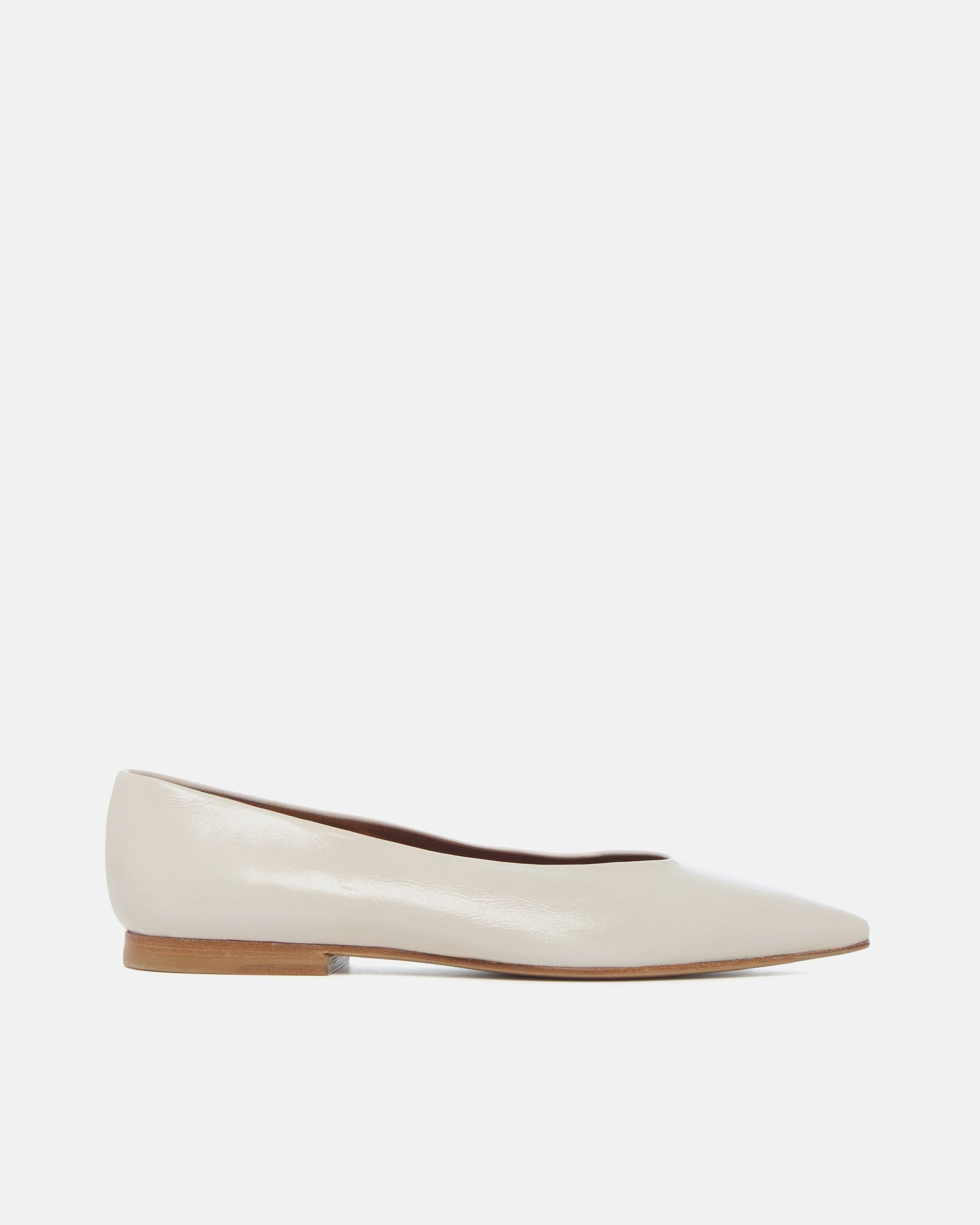Side view of a off-white patent leather pointed-toe flat with clean lines and a flexible leather sole, on a white background.