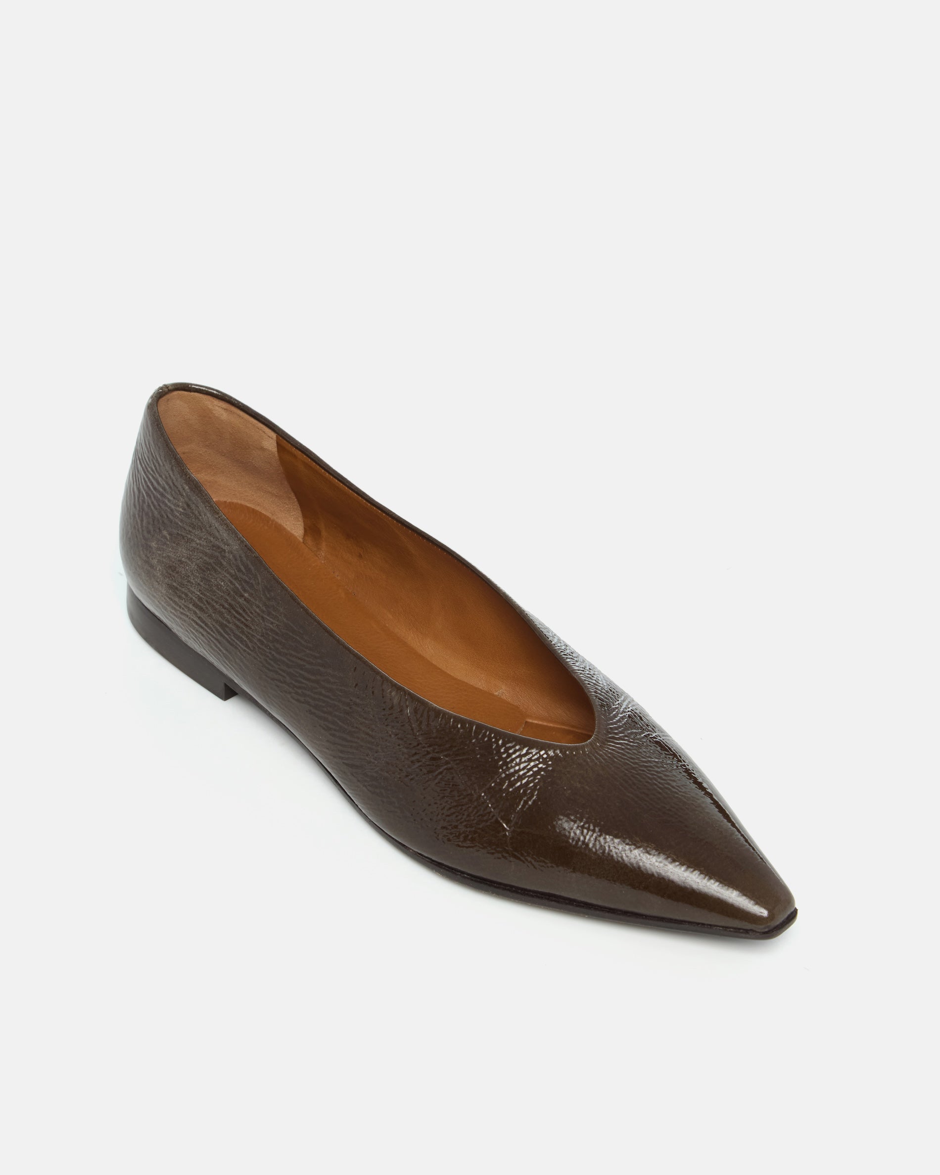 Dark brown patent leather pointed-toe flat shoe on a light grey background
