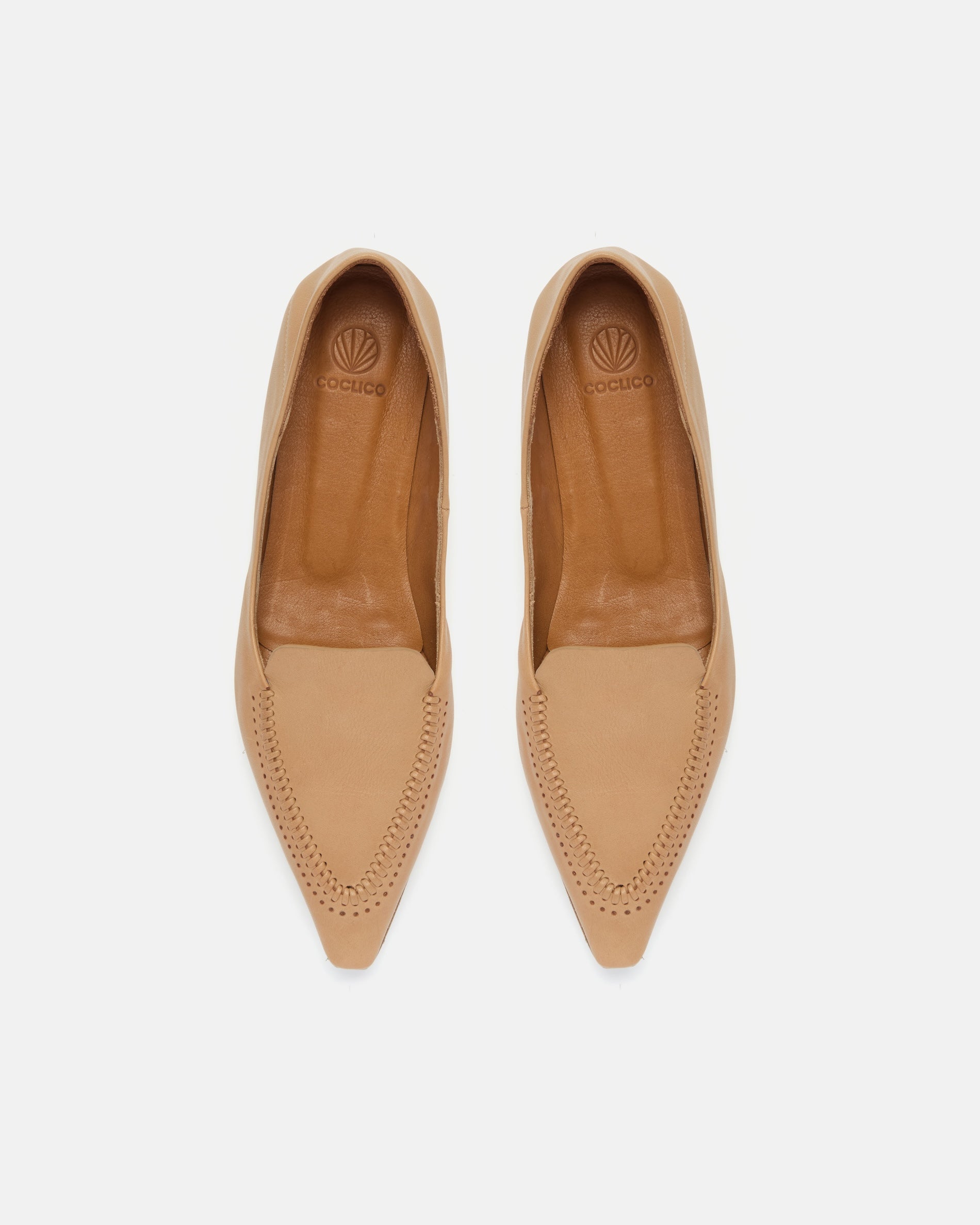 Top view of a pointed-toe camel leather loafer with topstitch detailing and a flat leather sole on a white background