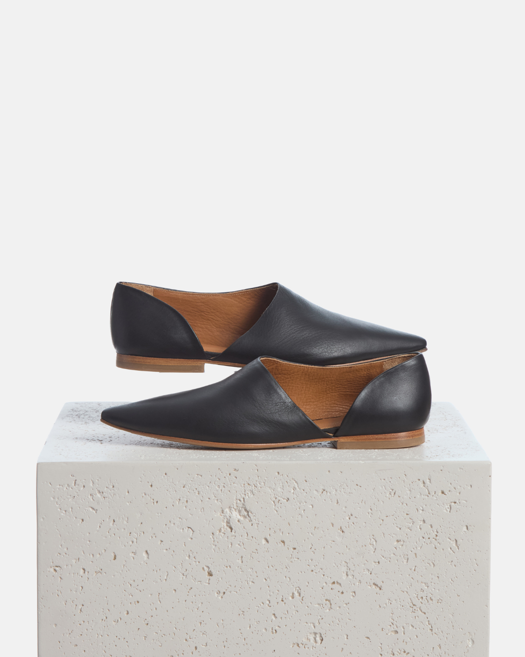 Coclico Coldplay Demi d'Orsay Flat in black leather, flats styled on a stone plinth
