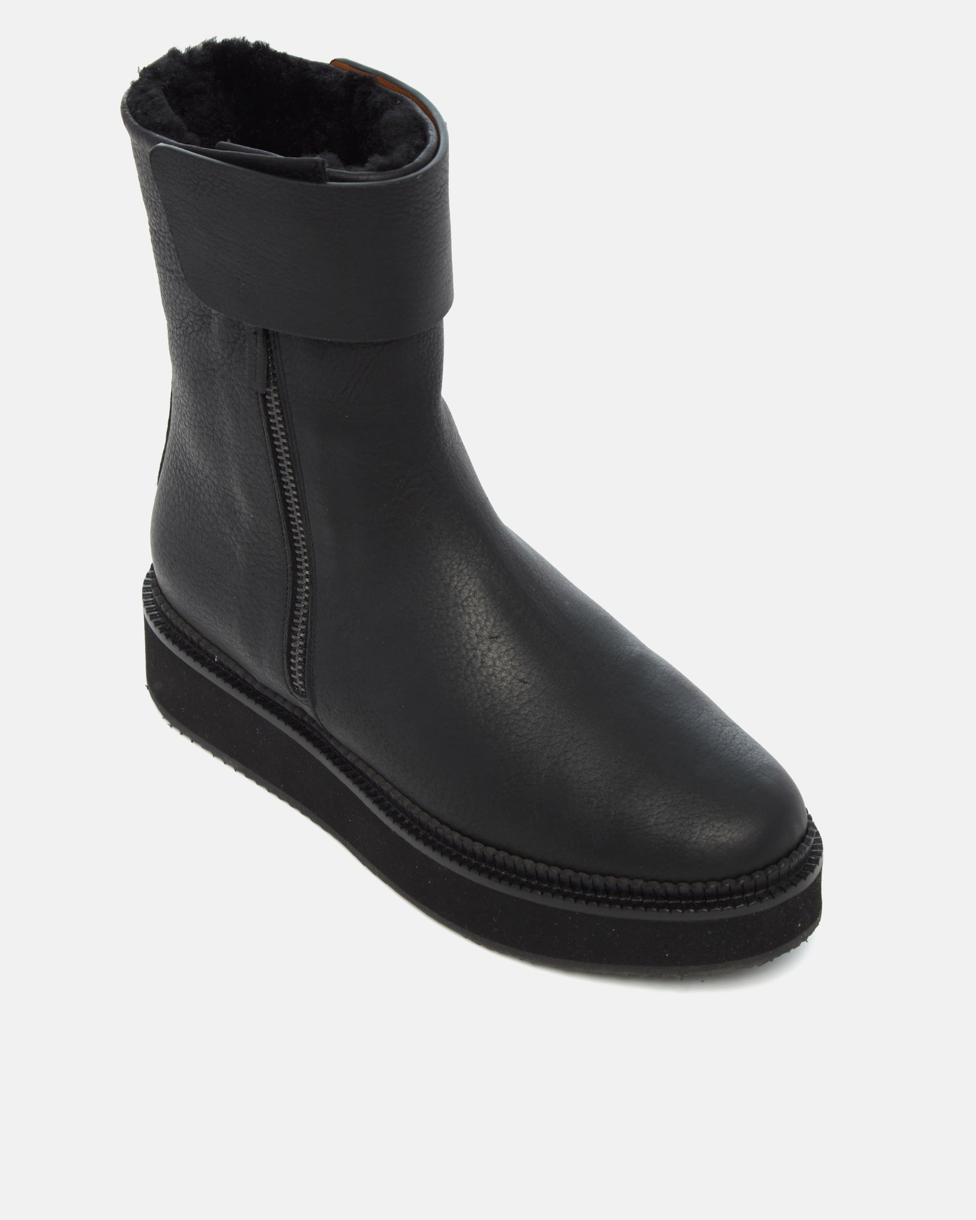 Coclico Greer Shearling Boot in black leather, angled view showing shearling collar