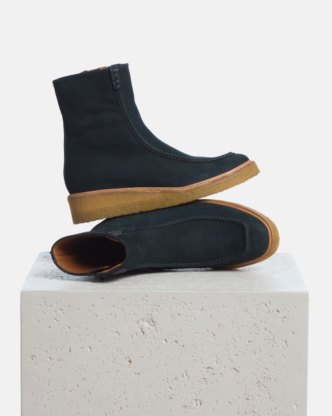 Coclico Haber Boot in Deep Sea nubuck, navy moc toe boots with crepe wedge soles styled on a stone plinth