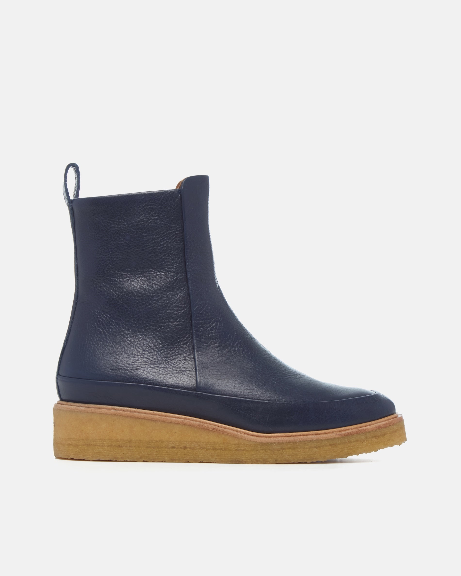 Coclico Hip Boot in Marino, side view of a navy leather ankle boot with natural crepe sole