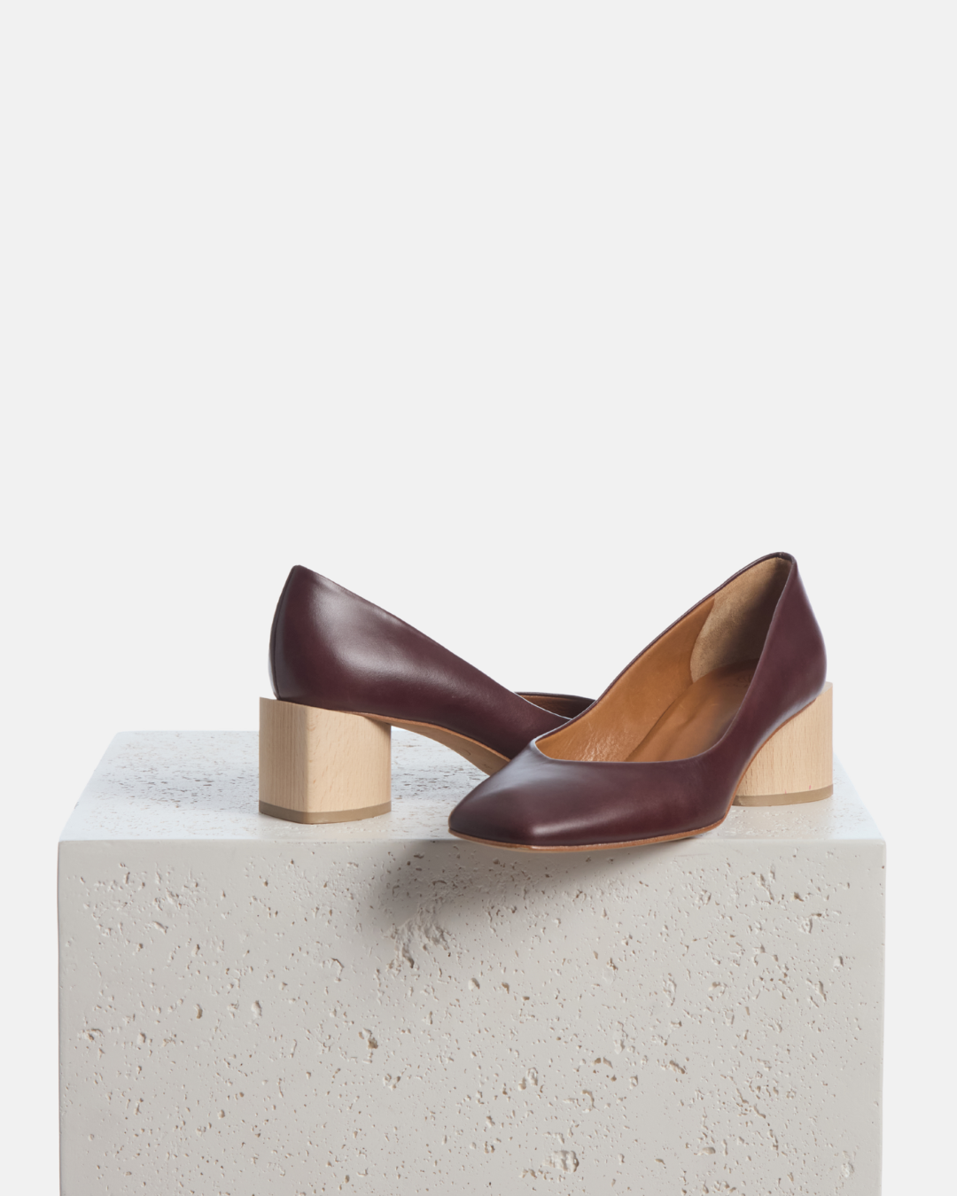 Coclico Icarus Pump in Oxblood leather, pumps with natural heels styled on a stone plinth