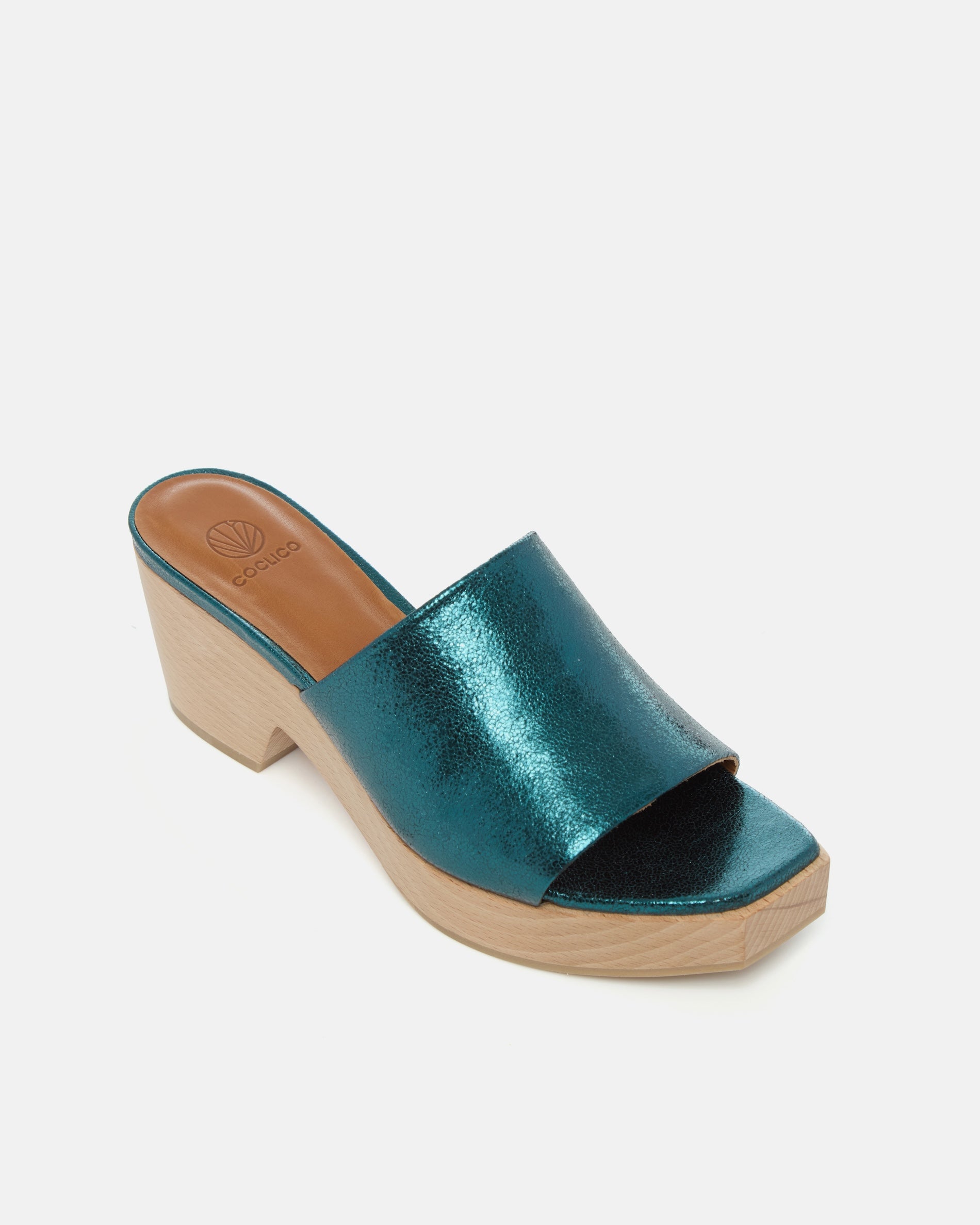 Angled view of a metallic blue leather slide clog with a wide upper, squared toe, and solid ash wood sole