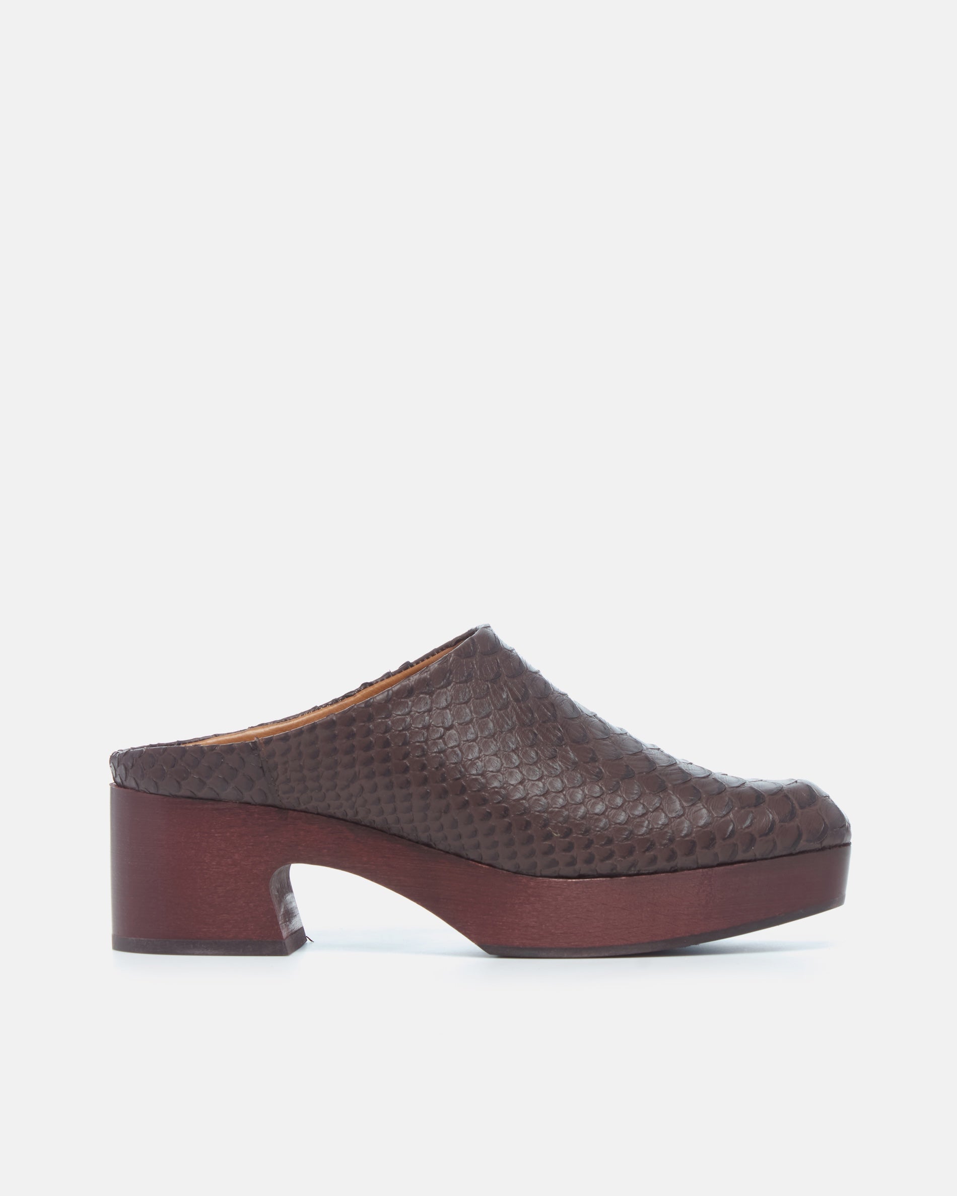 Coclico Quilla Clog in brown snake embossed leather, side view of a clog mule on a mahogany platform