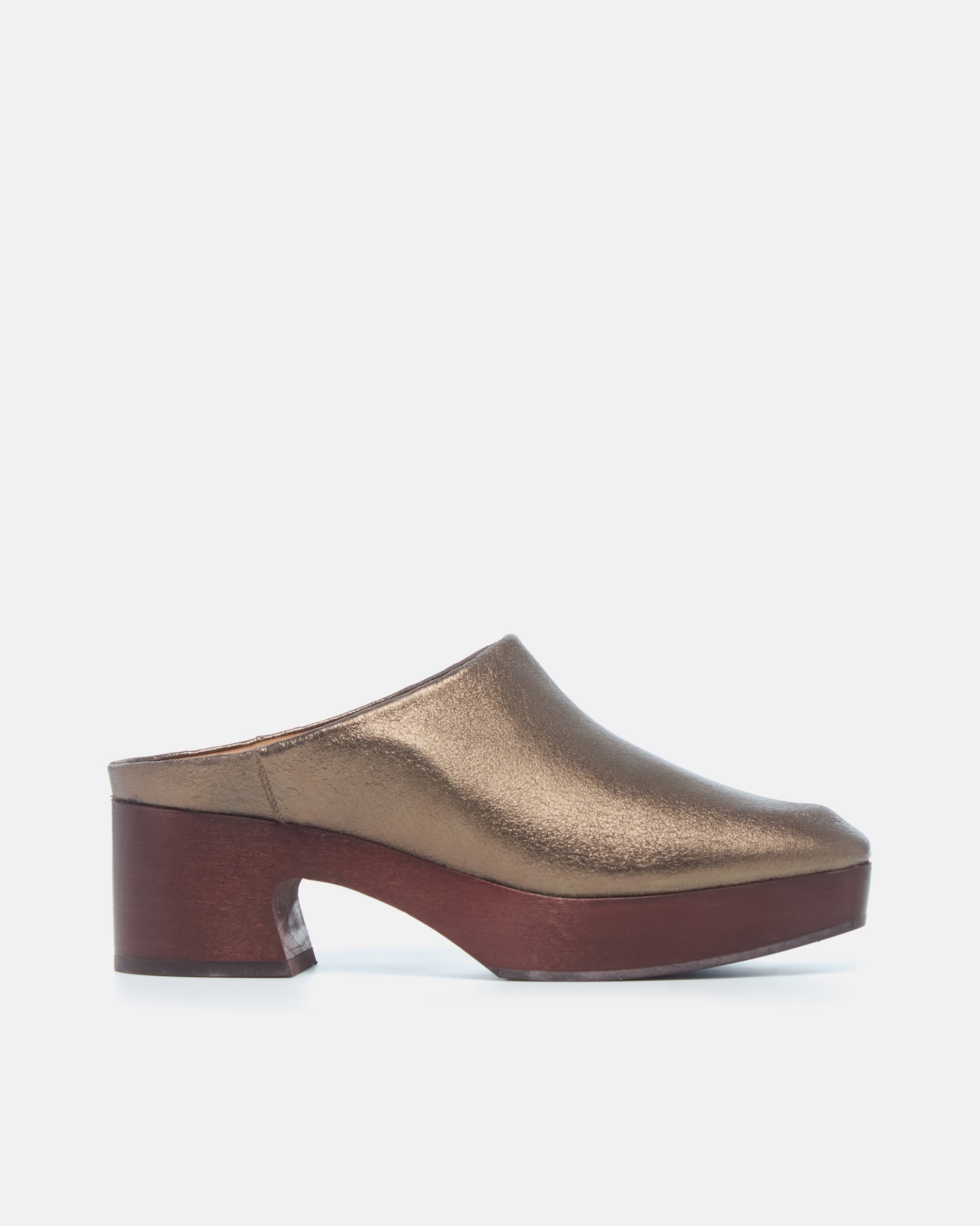 Coclico Quilla Clog in Bronze crinkled metallic, side view of a clog mule on a mahogany platform