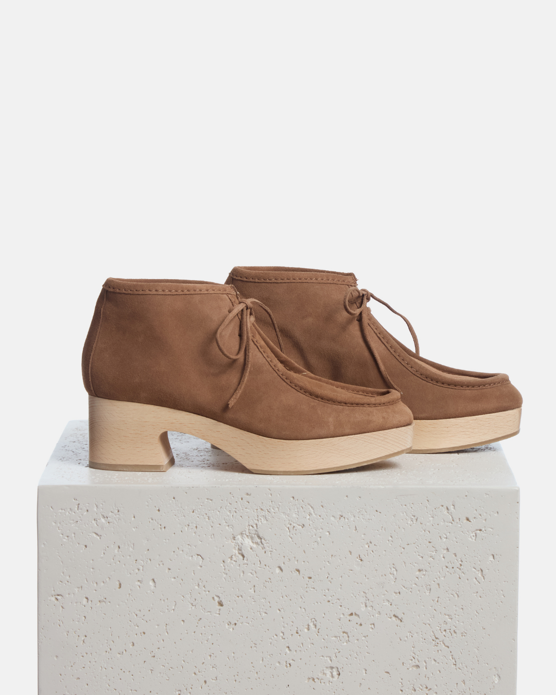 Coclico Quiterie Clog Boot in Dust split suede, lace up clog boots on natural wood bases styled on a stone plinth