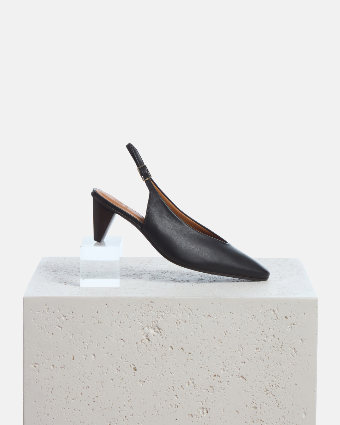 Coclico Sontag Slingback Pump in black leather, slingbacks with cone heels styled on a stone plinth