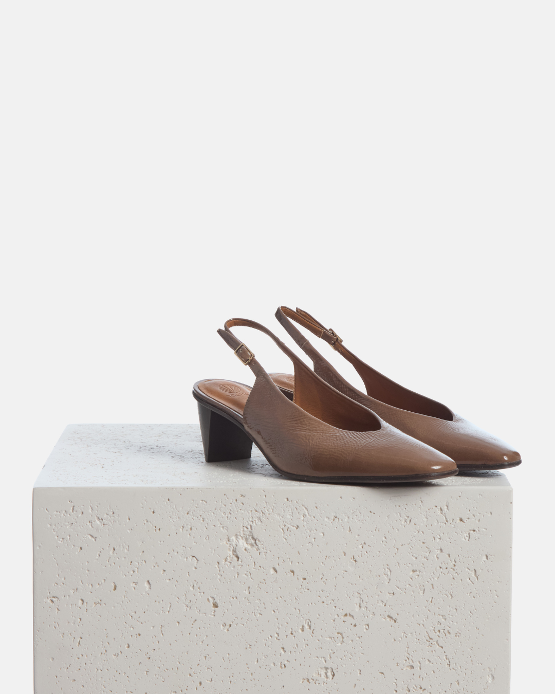 Coclico Sontag Slingback Pump in Boue crinkled patent, slingbacks with sculpted cone heels styled on a stone plinth