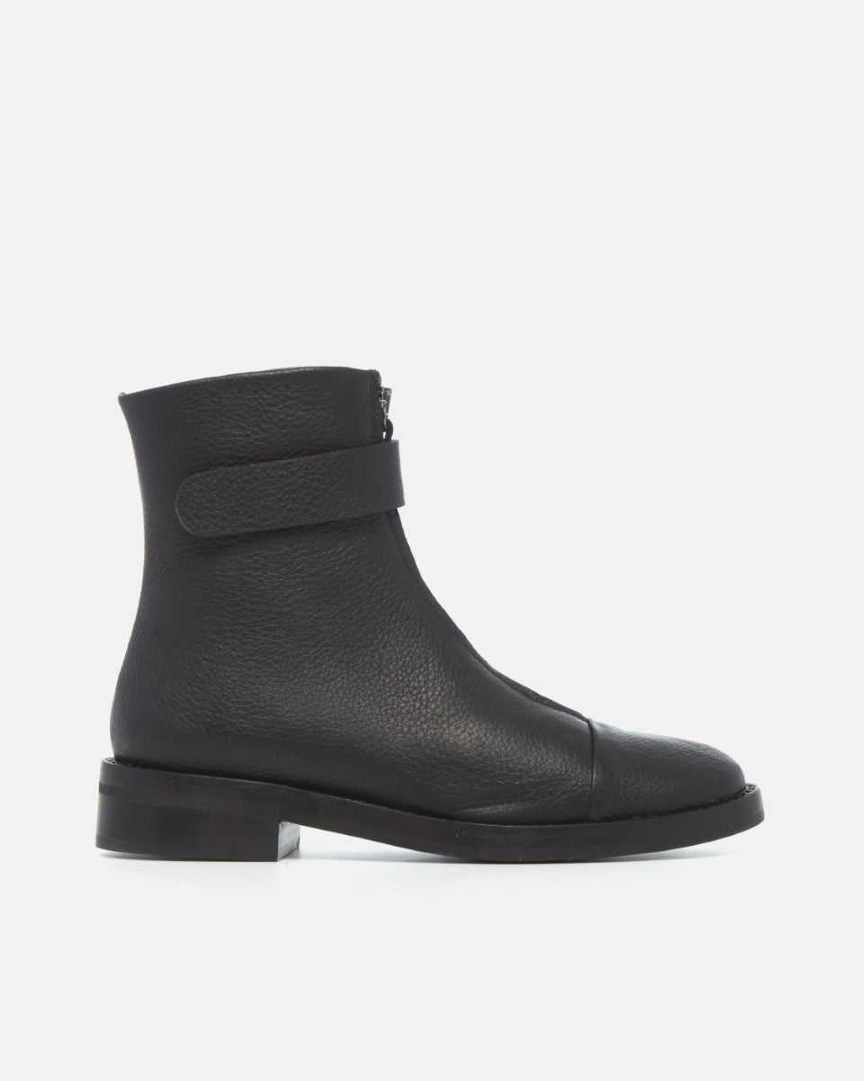 Coclico Thompson Boot in black leather, side view of a flat boot with fold over strap and cap toe