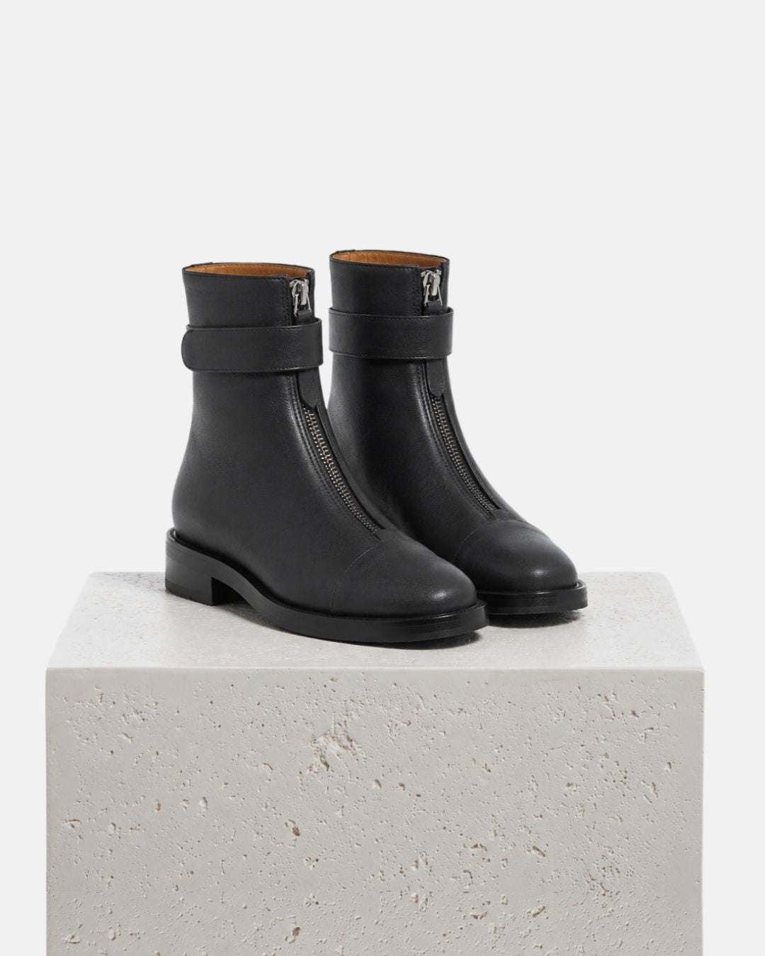 Pair of Coclico Thompson Boots in black leather, front view showing front zips, on a plinth