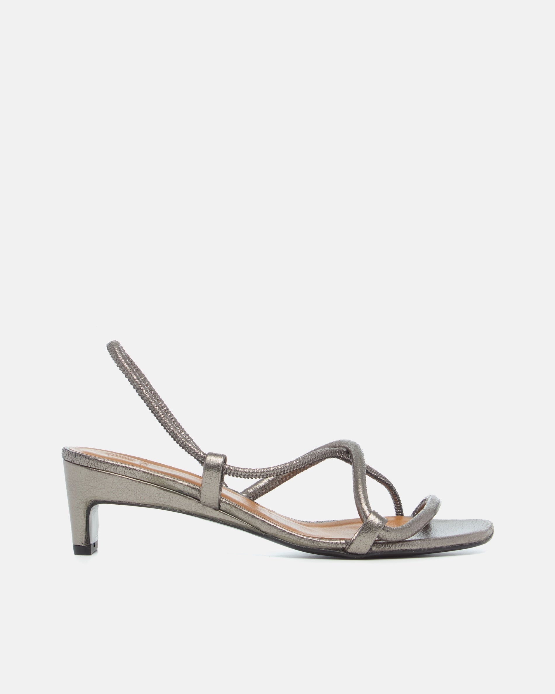 Side view of a metallic pewter leather mid-heel sandal with slim crossover straps, an elastic slingback, and a softly contoured demi heel.