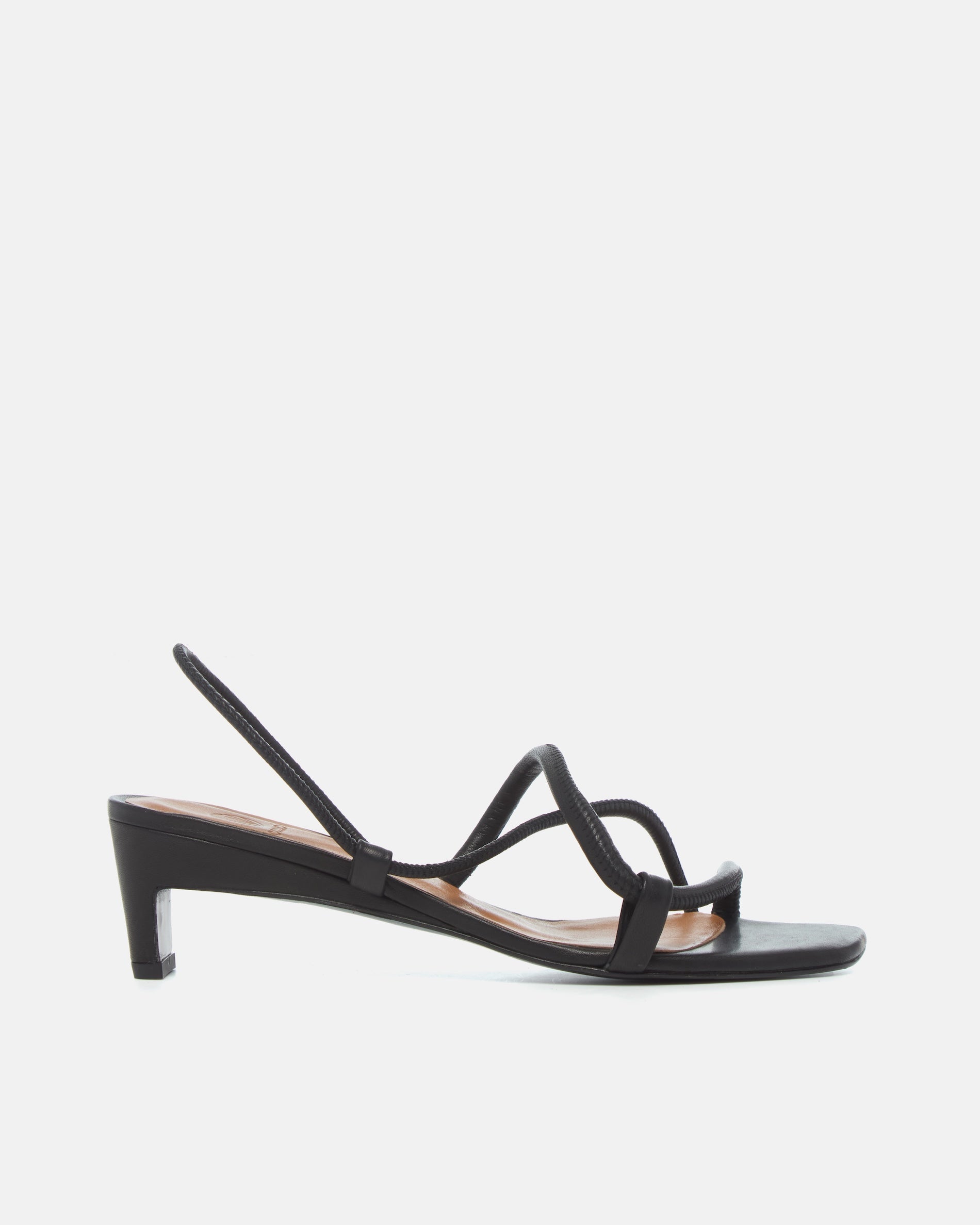 Side view of a black leather mid-heel sandal with slim straps, elasticized slingback, and a graceful demi heel