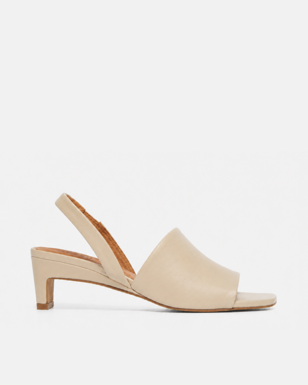 Side view of a Coclico slingback mid-heel off-white sandal with wide front band.
