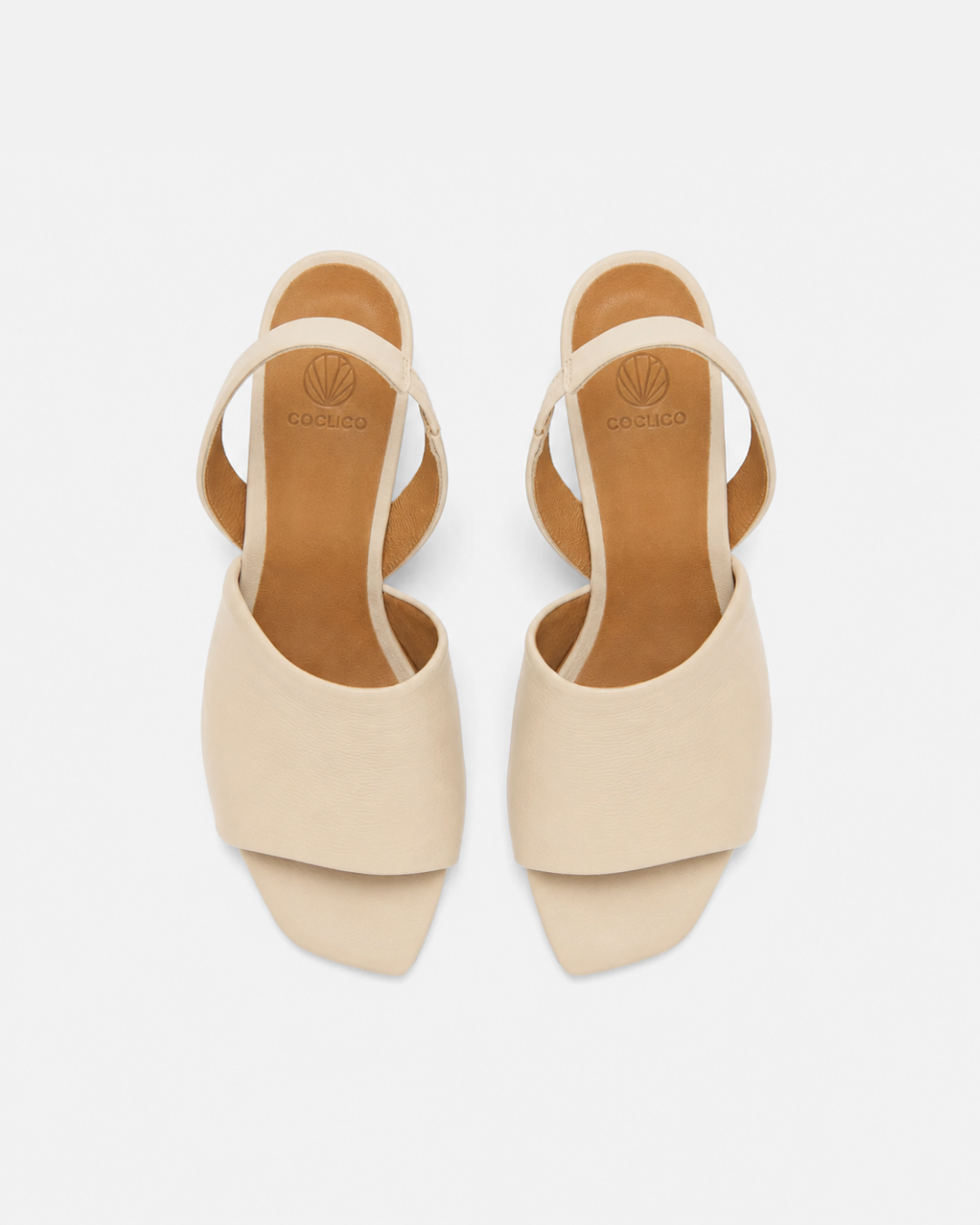 Top view of a Coclico slingback mid-heel off-white sandal with wide front band.