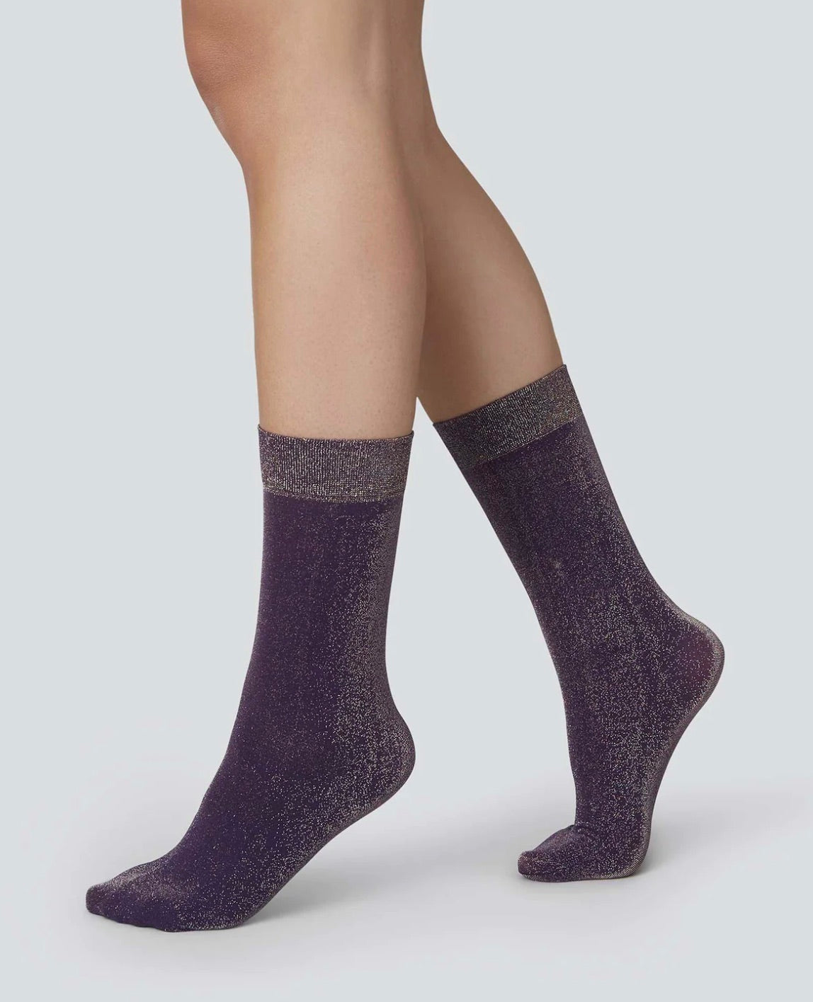 Shimmery socks shown worn on a woman's legs