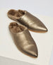 Metallic gold, pointed-toe slippers with a soft, furry interior lining and a smooth, leather-like exterior. 2