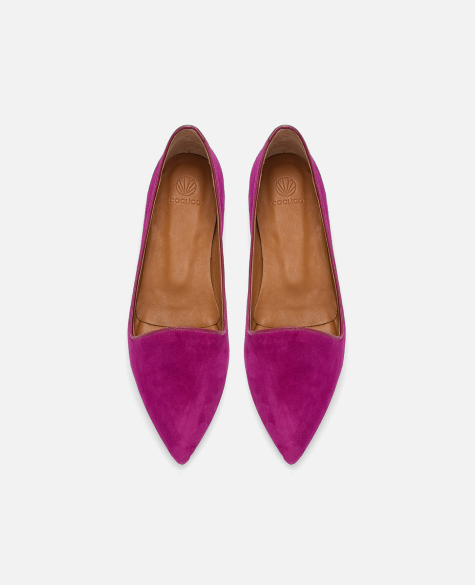 Pair of pink suede shoes with brown soles on a white background