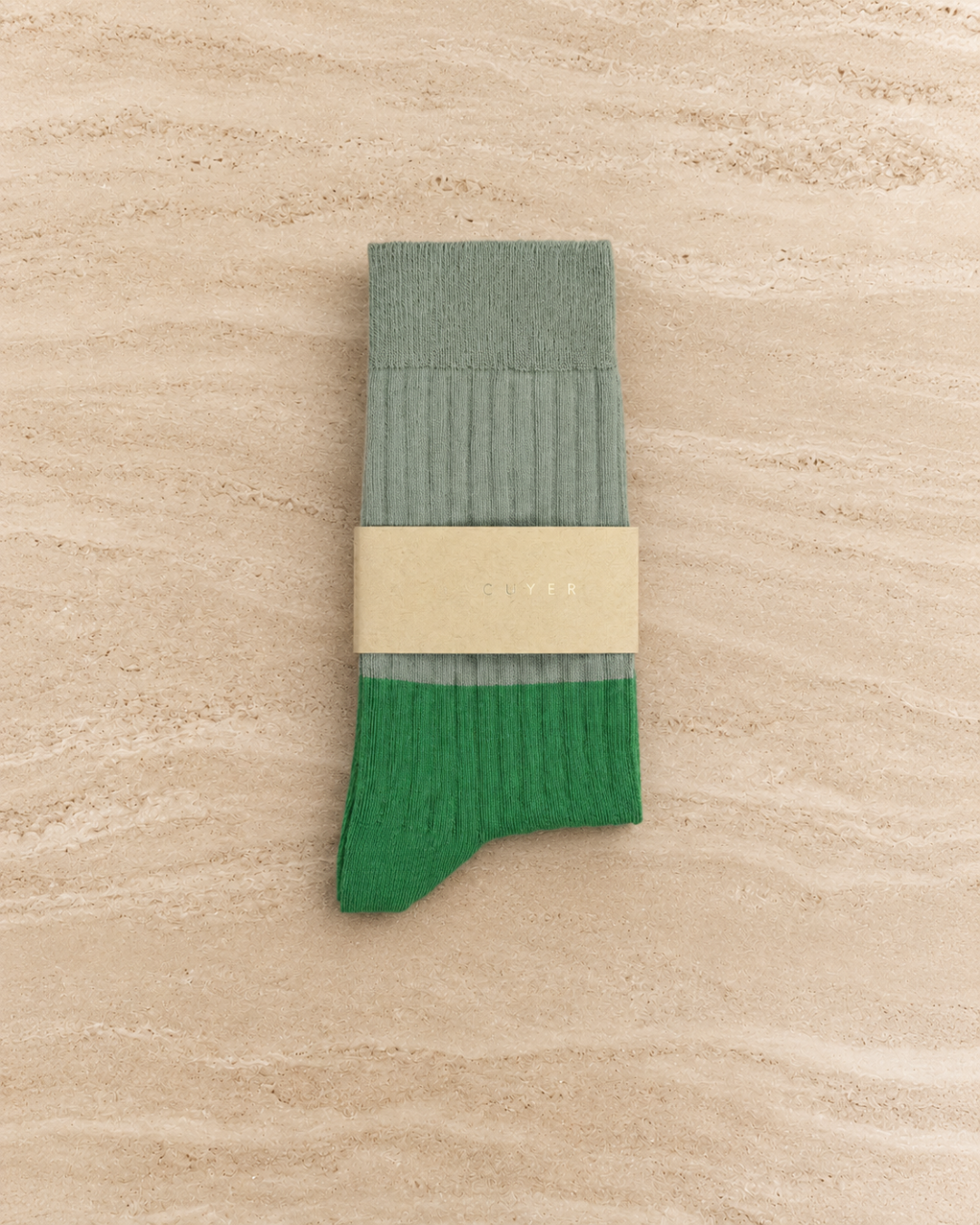 Escuyer Green sock with beige label on a white background