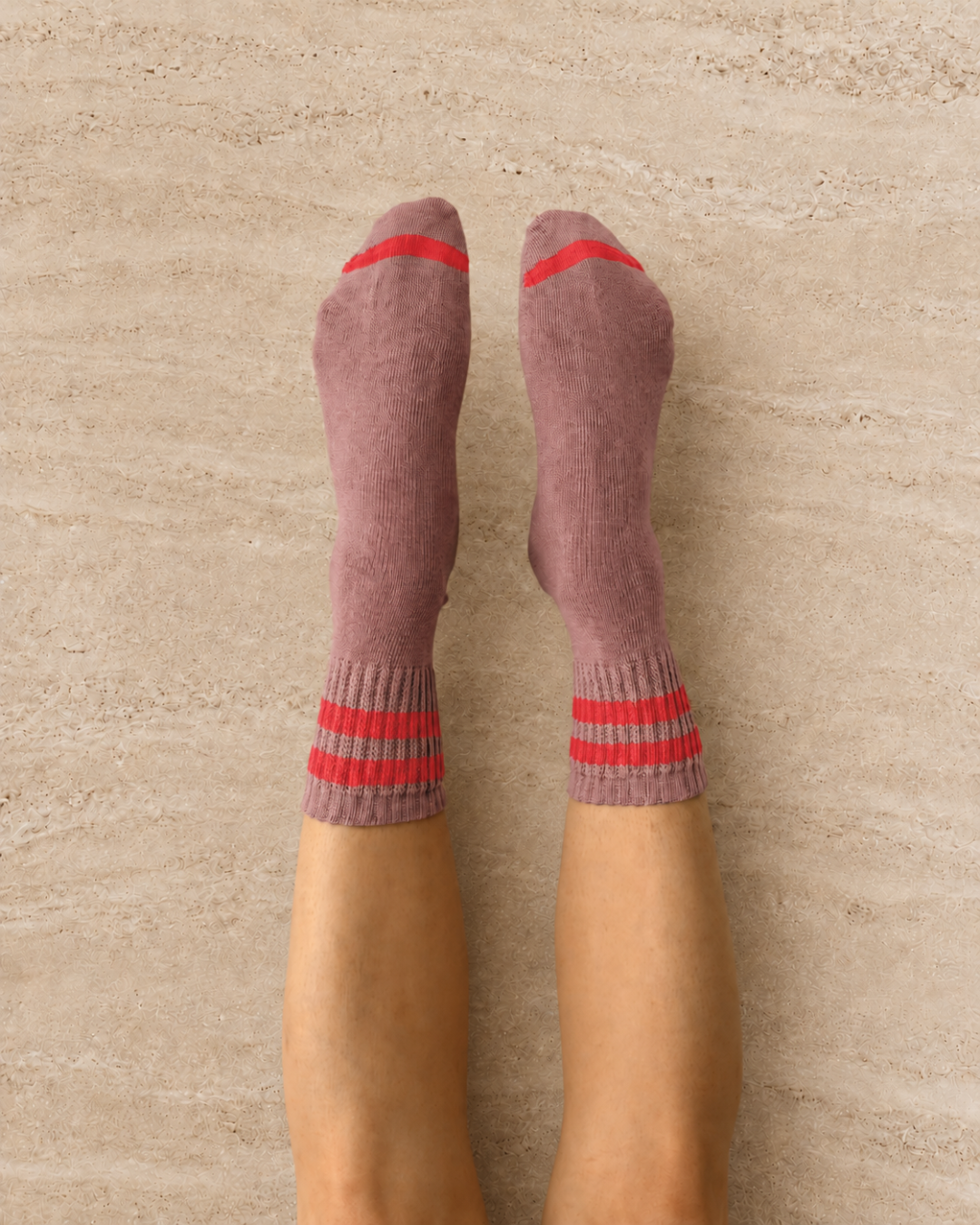 Escuyer Purple socks with red stripes worn by a person on a light gray background