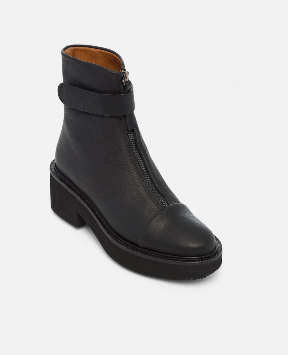 Black leather ankle boot with a strap and zipper on a white background