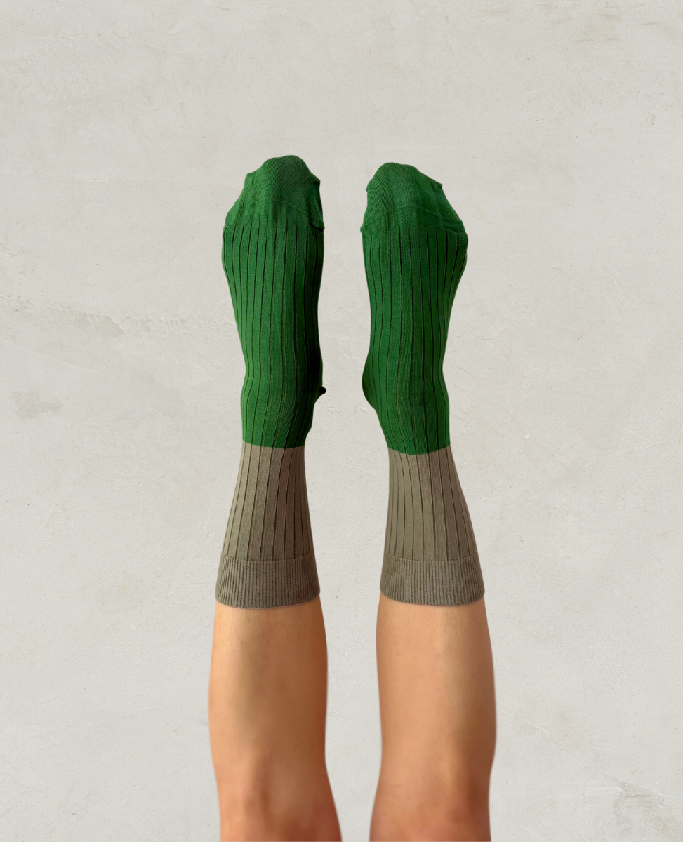 Escuyer Green and gray socks worn by a person on a light gray background