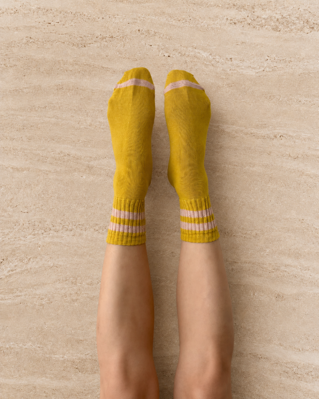 Escuyer Yellow sock with pink stripes modeled on the foot