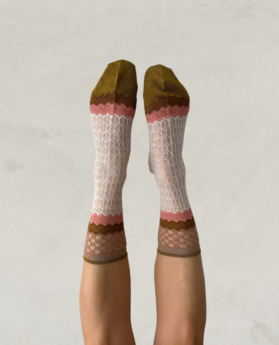 Exquisite J Patterned socks worn on a plain background