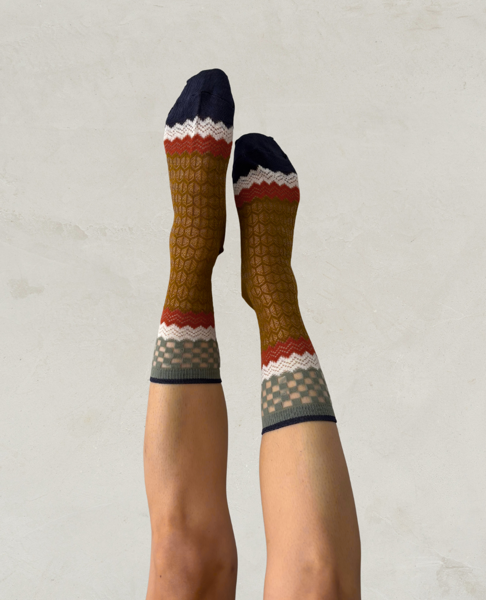 Exquisite J Pair of patterned socks worn on a plain background