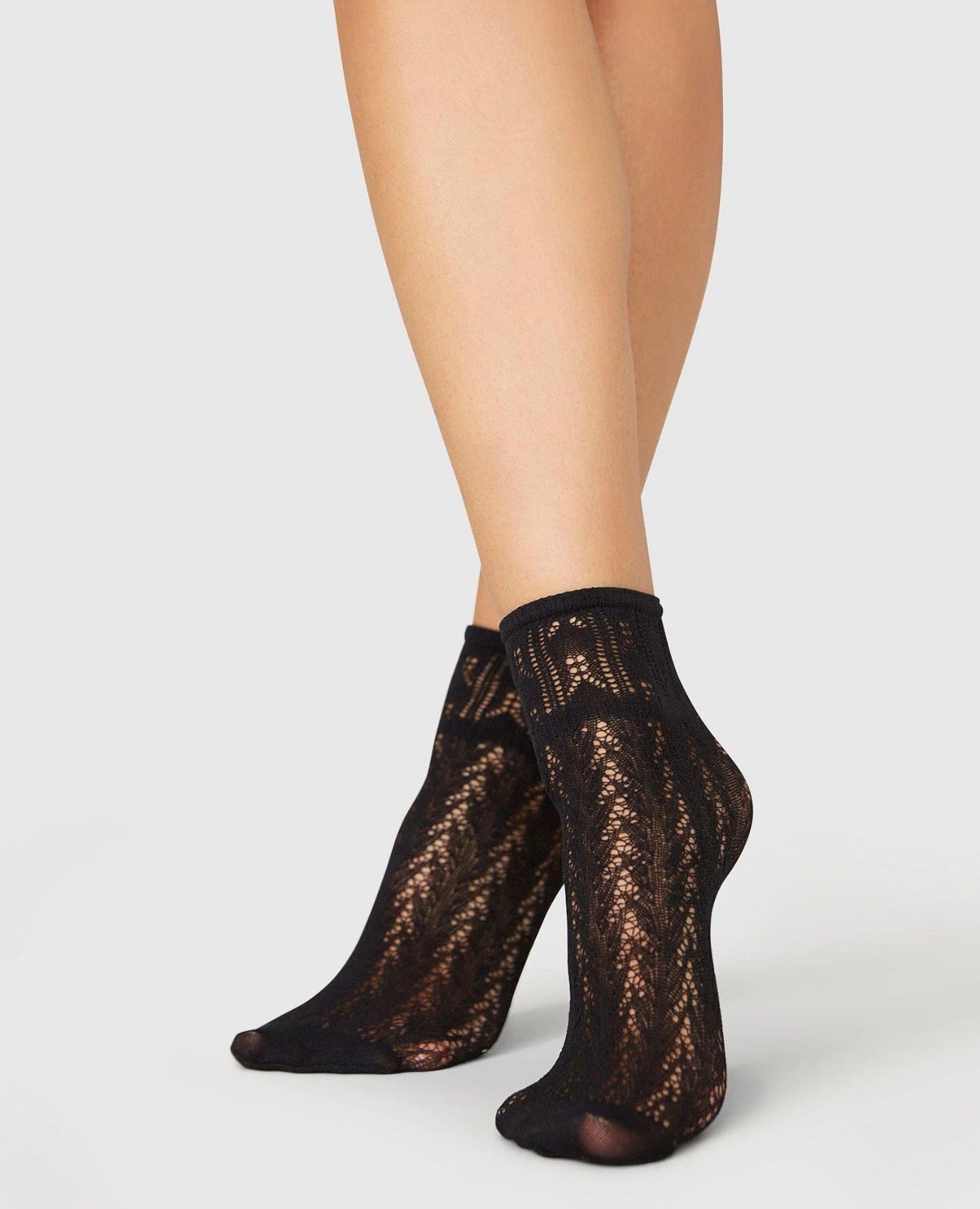 Black lace ankle socks featuring an intricate floral pattern, semi-sheer texture, and a snug, elasticized cuff.