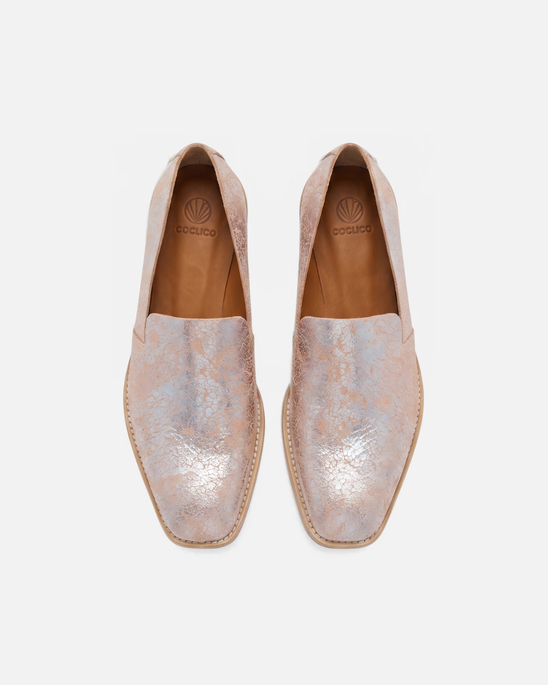 Pair of light pink loafers with metallic finish on a white background