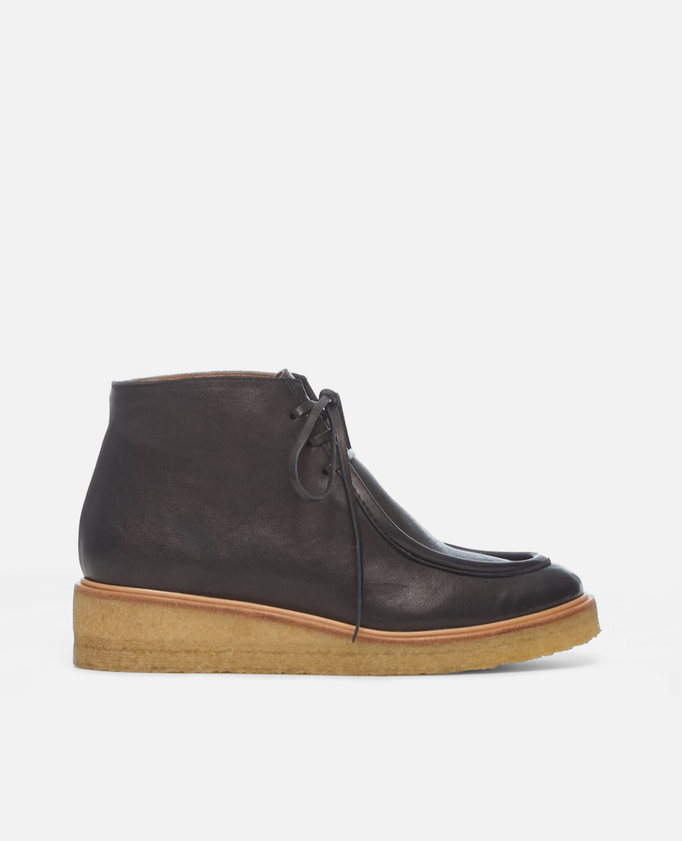 Black leather ankle boot with a brown sole on a white background