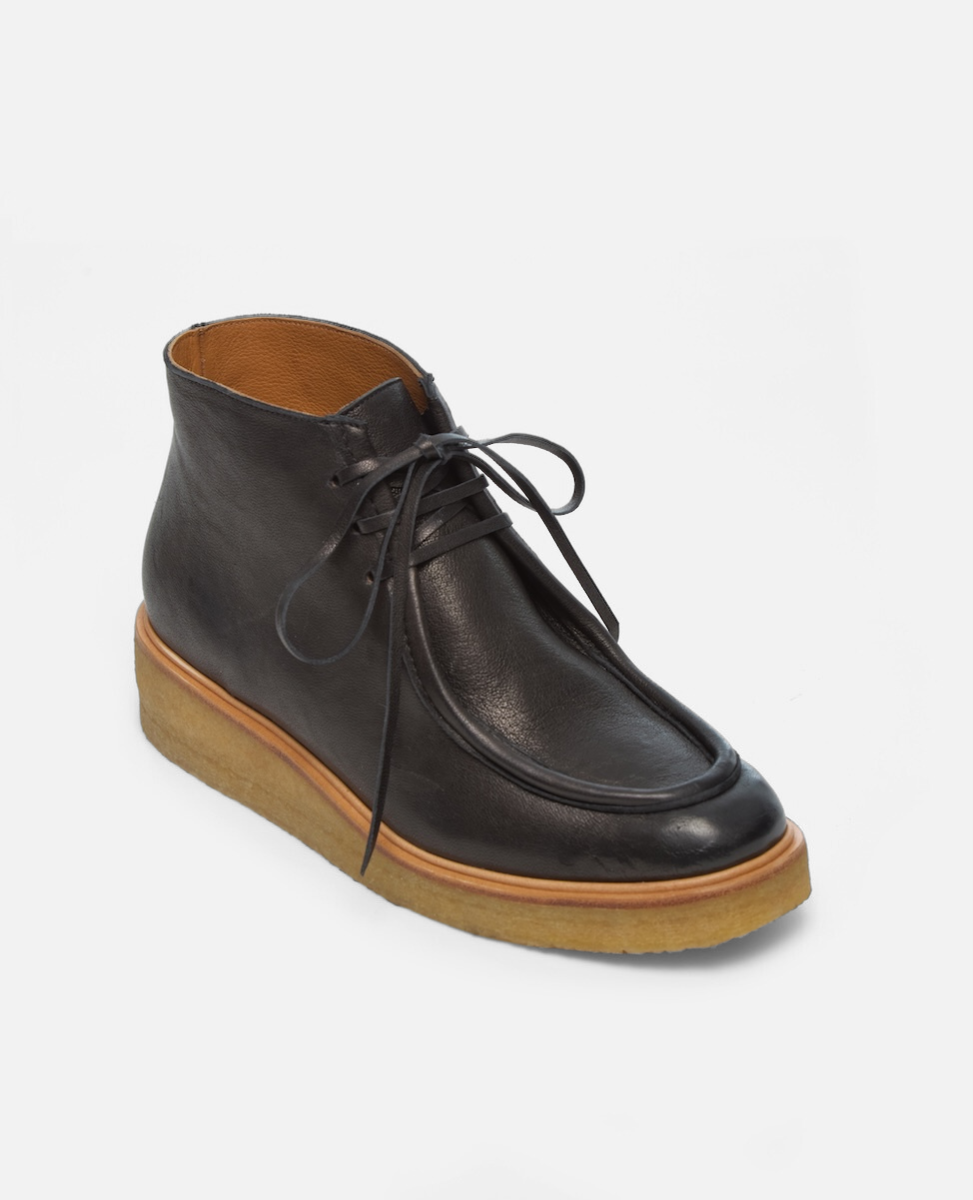 Black leather boot with brown sole on a white background