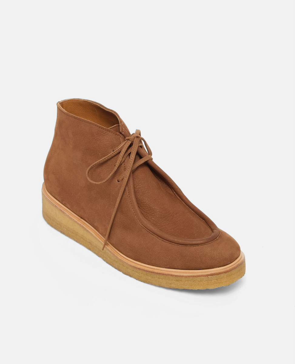 Brown suede shoe on a light gray background