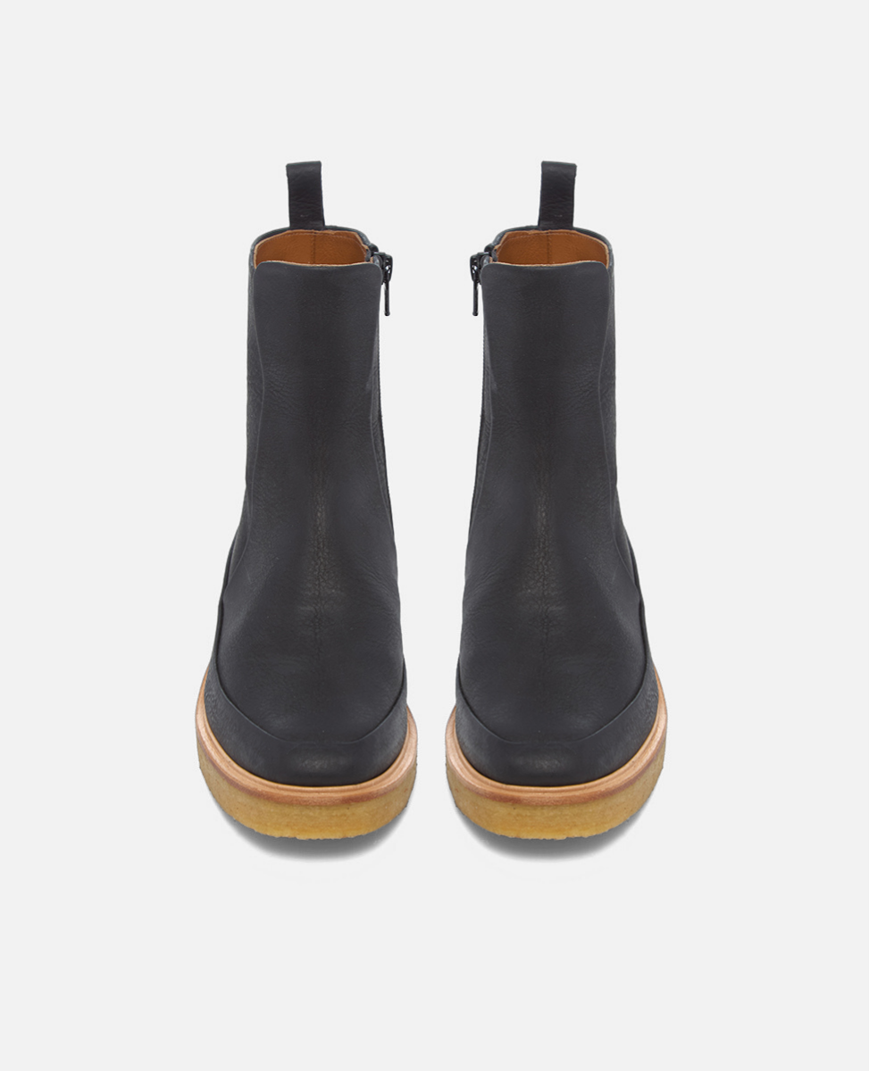 Pair of black leather ankle boots with brown soles on a white background