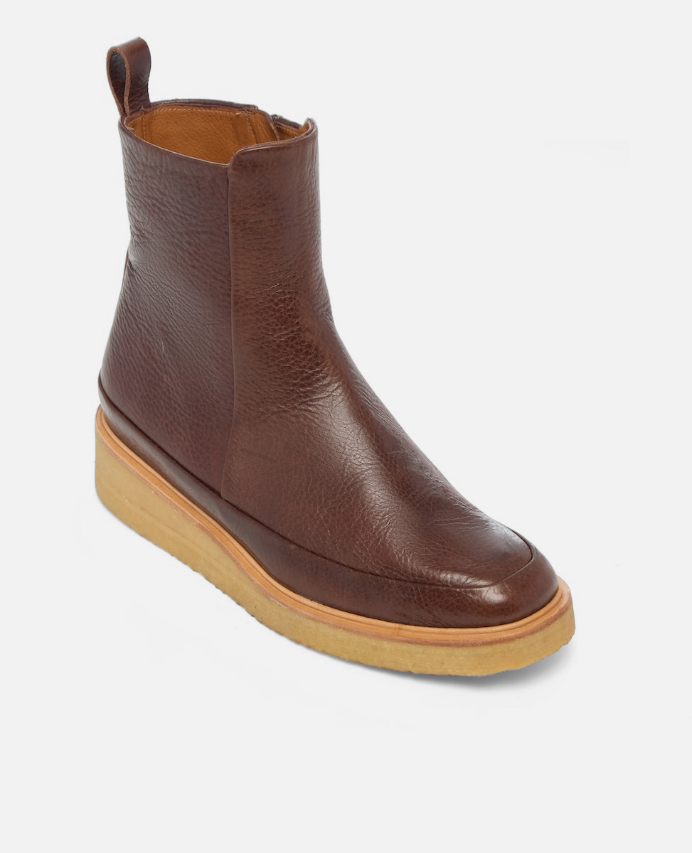 Brown leather ankle boot with a wooden sole on a light gray background